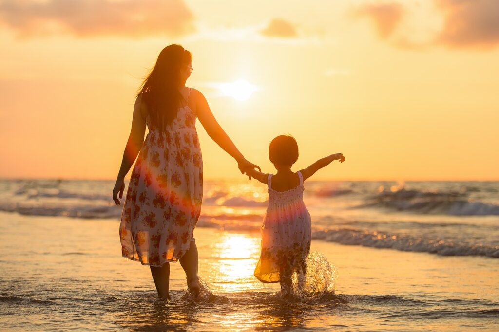 Mother and young daughter by the beach at sunset.  Motherhood changed my approach towards time and priorities.